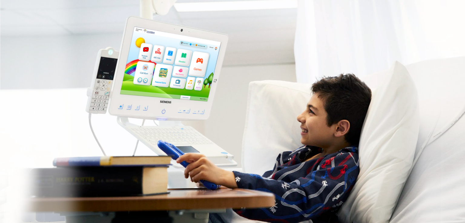 Elderly patient with daughter and nurse talking around HiMed Cockpit with My Care Plan screen copy 1